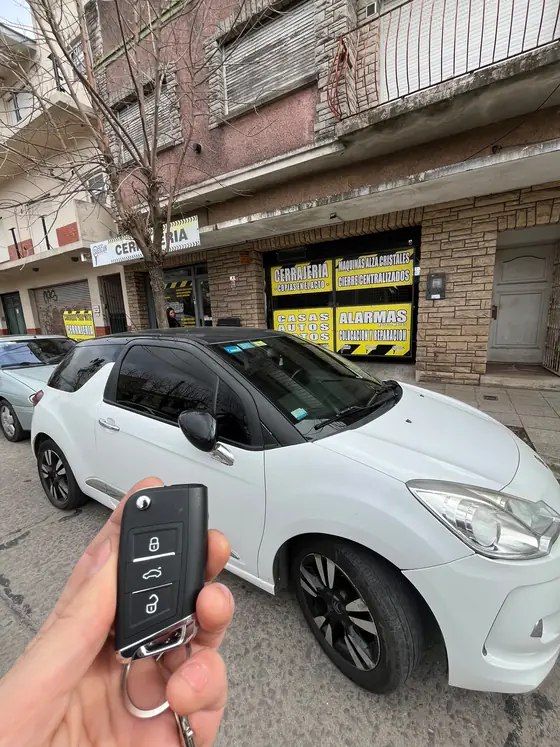 Citroën blanco frente al local, con los carteles de máquinas alza cristales, cierres centralizados y alarmas