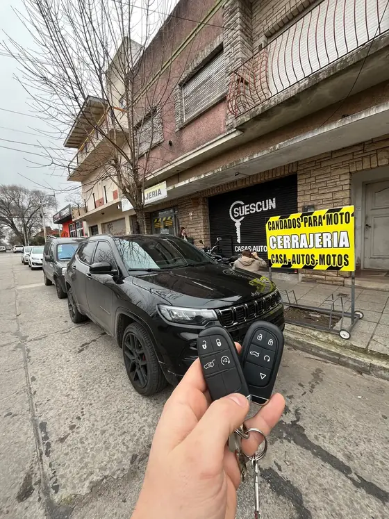 Frente del local de Cerrajería Suescun con un Jeep Compass y sus dos llaves