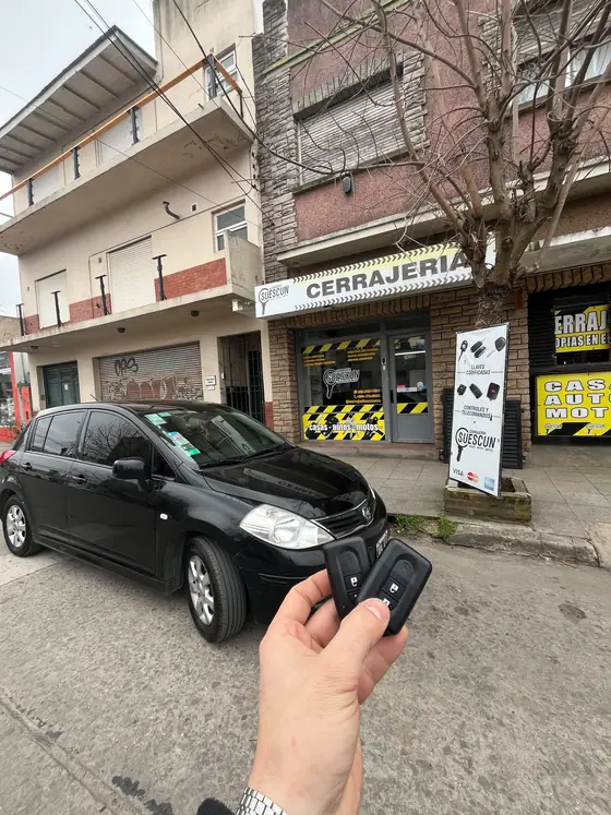 Nissan negro frente al local con dos telemandos